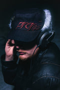 Person wearing the ANTIFRAGILE Military Hat with fur flaps showcasing the custom maroon red 3D puff print embroidery and embellished with custom designed pins.