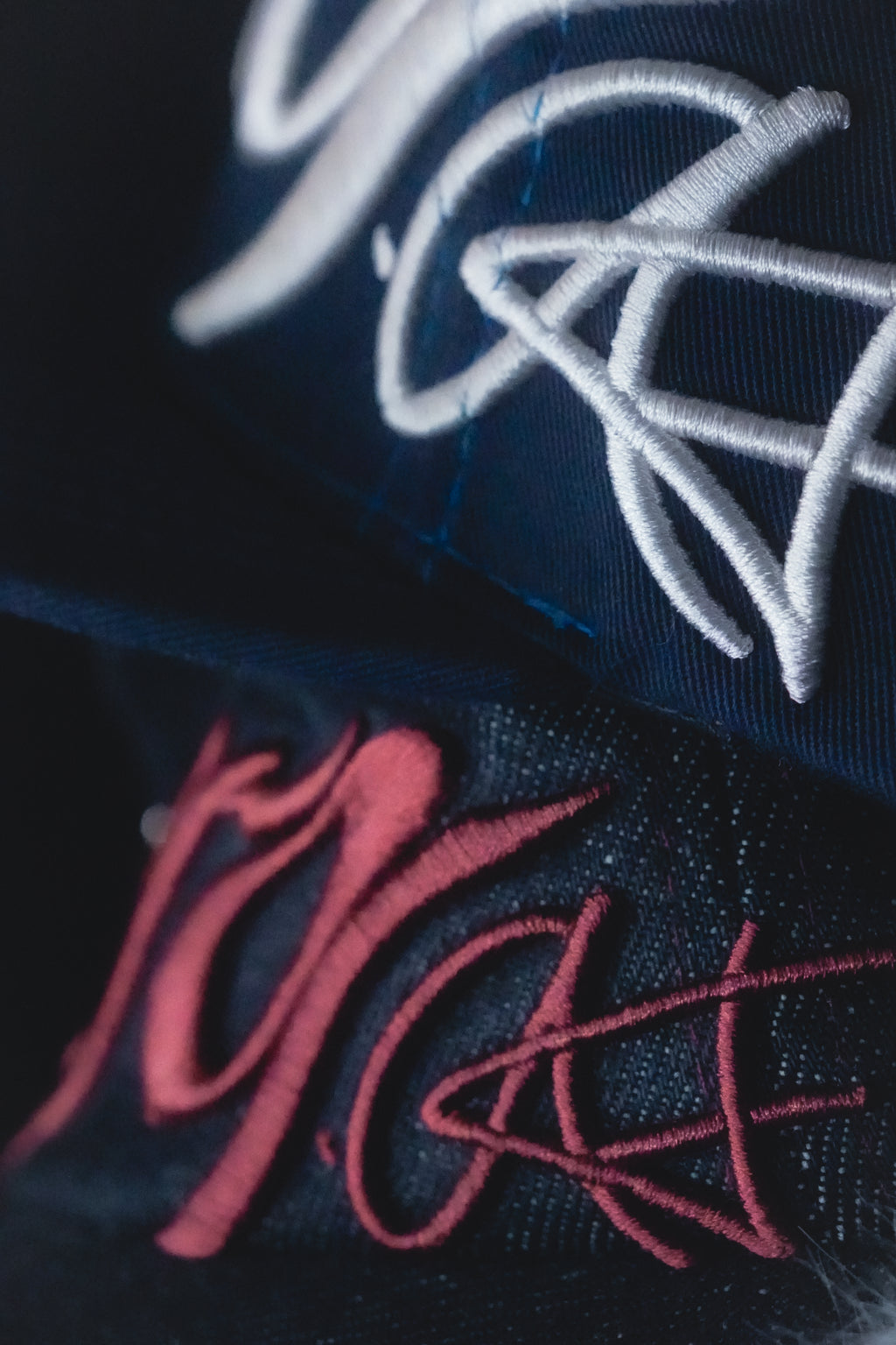 Close-up of embroidered hat designs on a dark fabric background