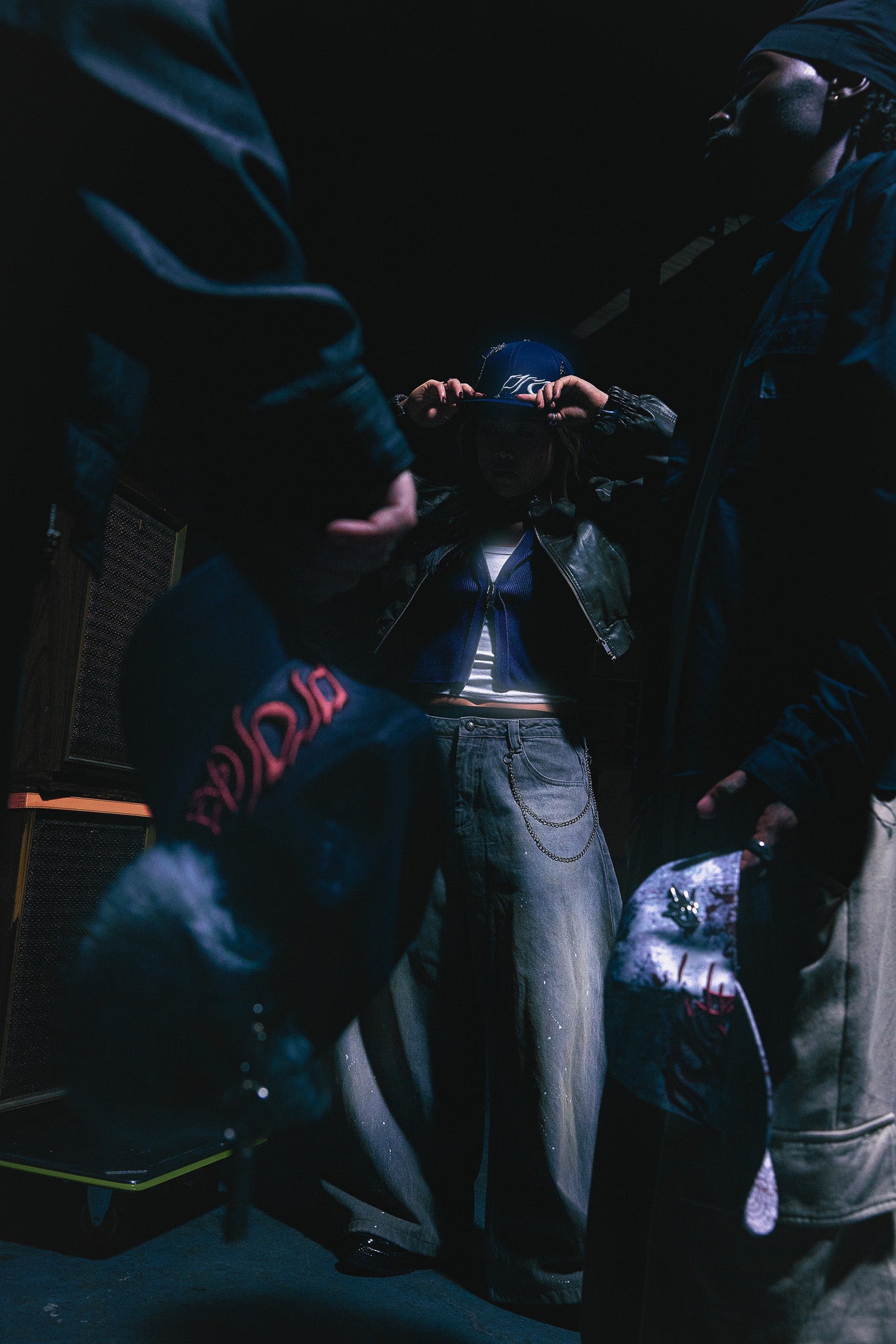 3 creatives each wearing a unique silhouette of the AS WE ARE Collection. The military fur cap, camo strapback and navy blue fitted hat are seen. 